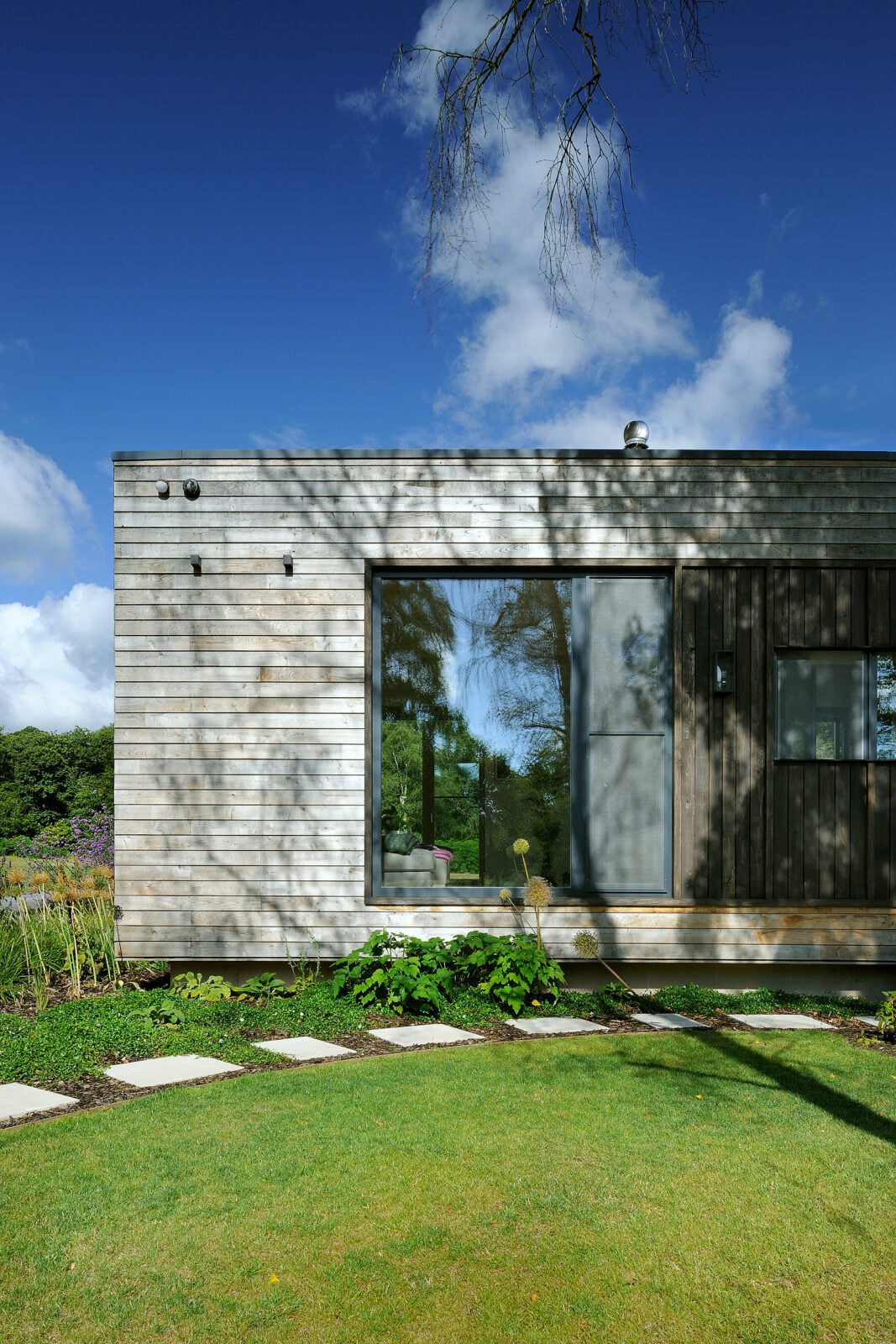 Timber cladding of forest lodge and nature in the reflections